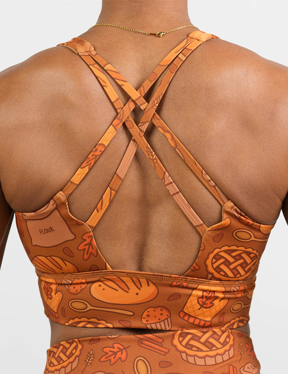 back of the orange baking themed sports bra against a white background