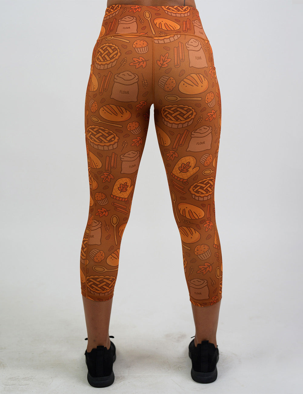back of the orange baking themed capri leggings against a white background