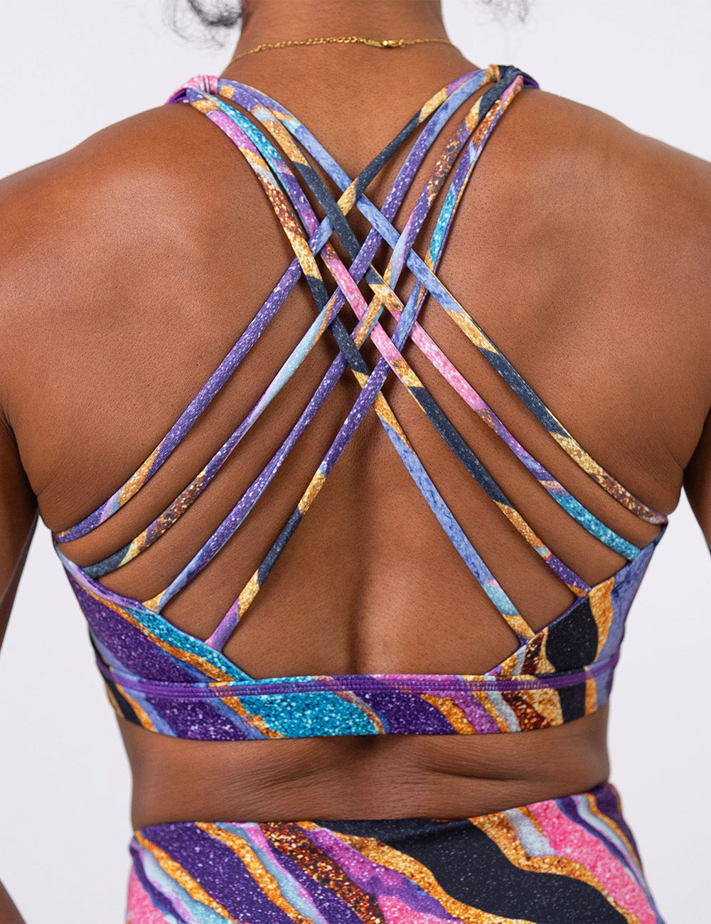 back of the purple, gold, black, blue, and pink abstract stripes sports bra
