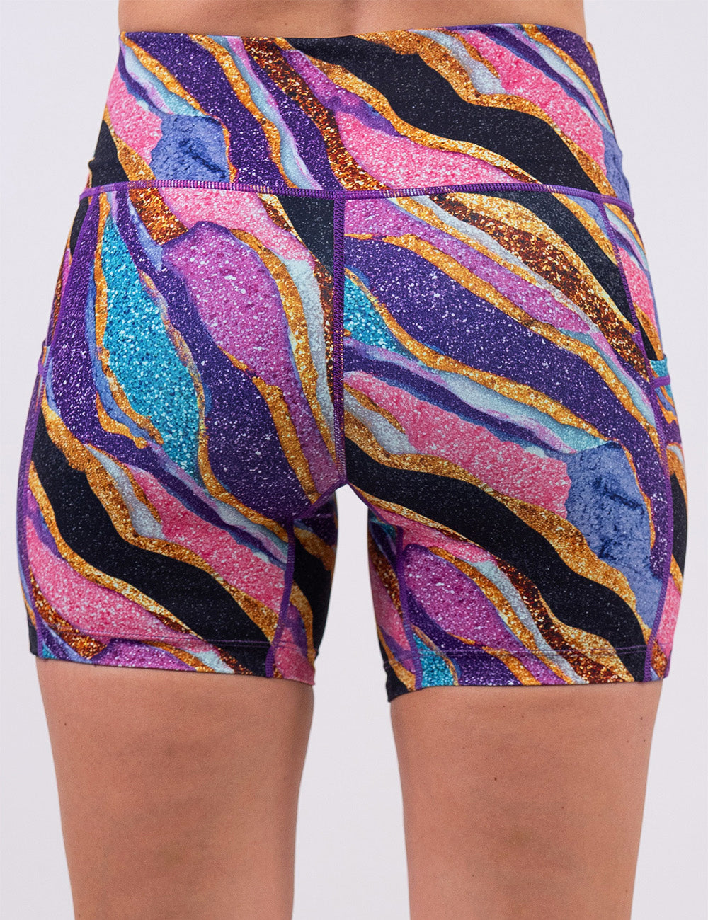 back of the purple, gold, black, blue, and pink abstract stripes 5 inch shorts against a white background