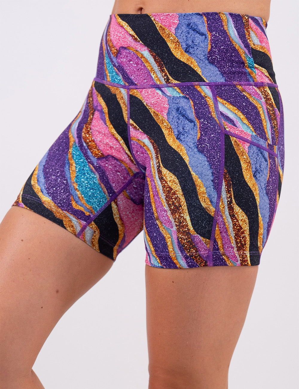 front of the purple, gold, black, blue, and pink abstract stripes 5 inch shorts against a white background