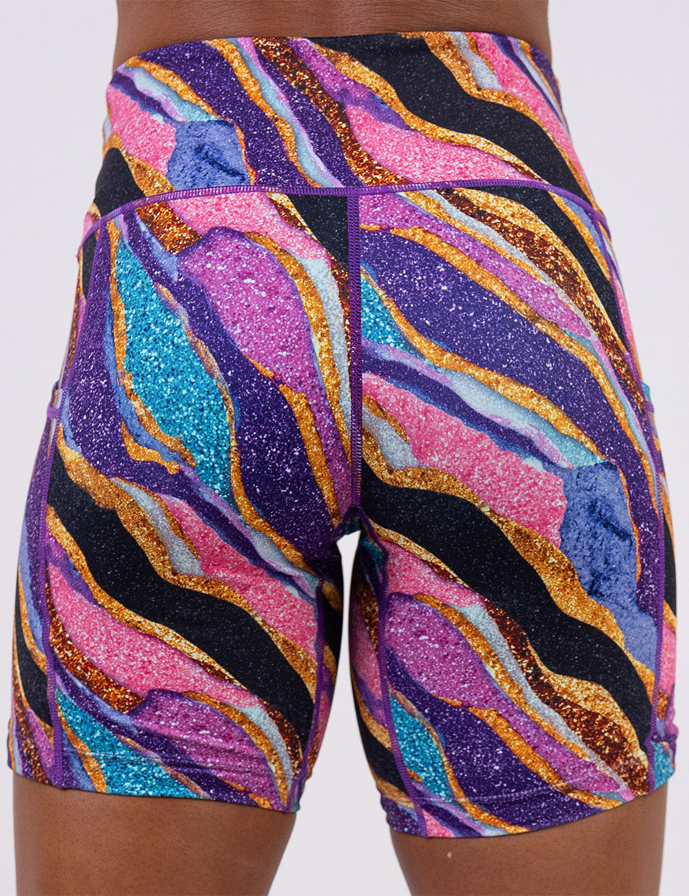 back of the purple, gold, black, blue, and pink abstract stripes 7 inch shorts against a white background