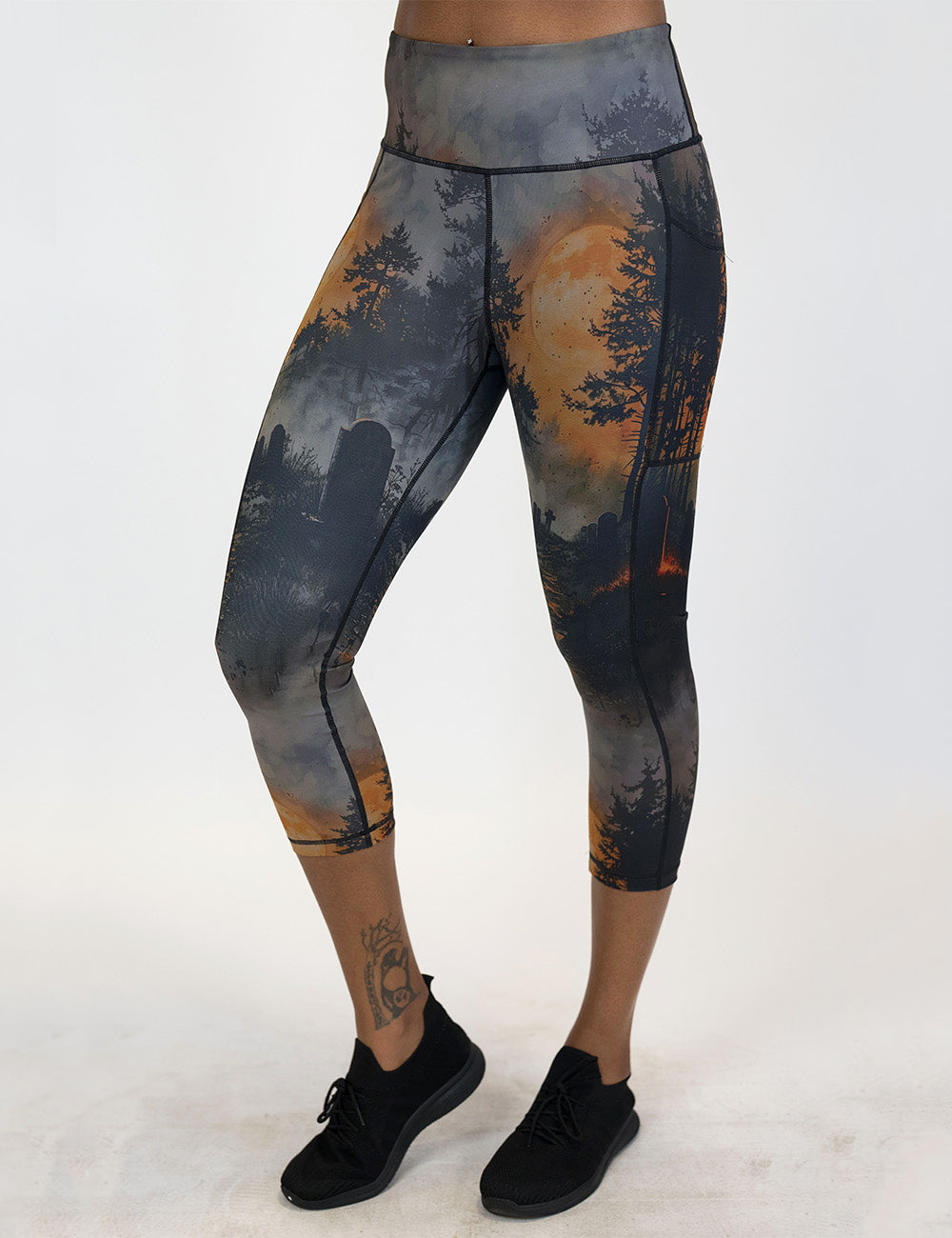 front of the dark cemetery with a full moon capri leggings against a white backgruond