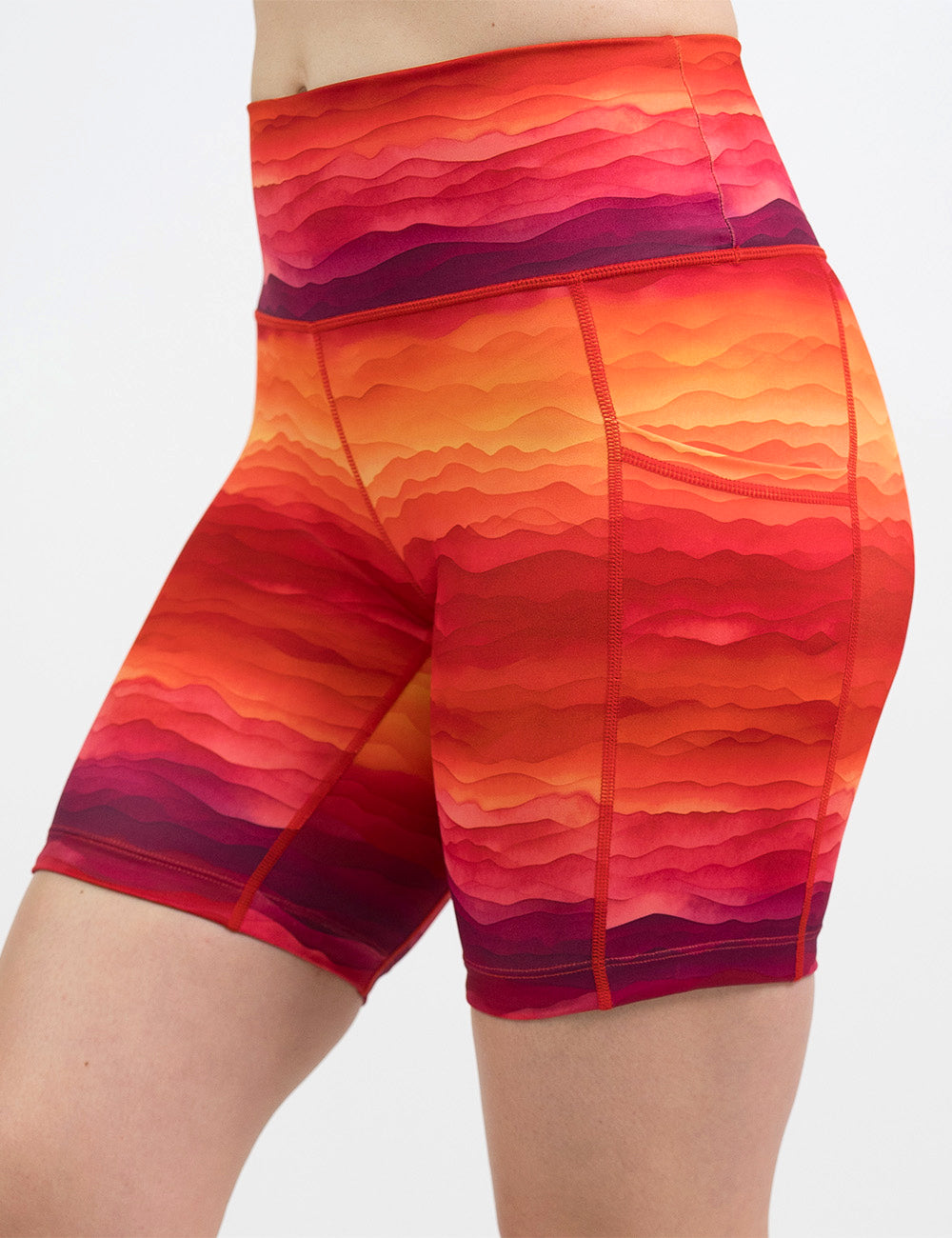 front of the 7 inch red, yellow, and orange sunset stripes pattern shorts against a white background