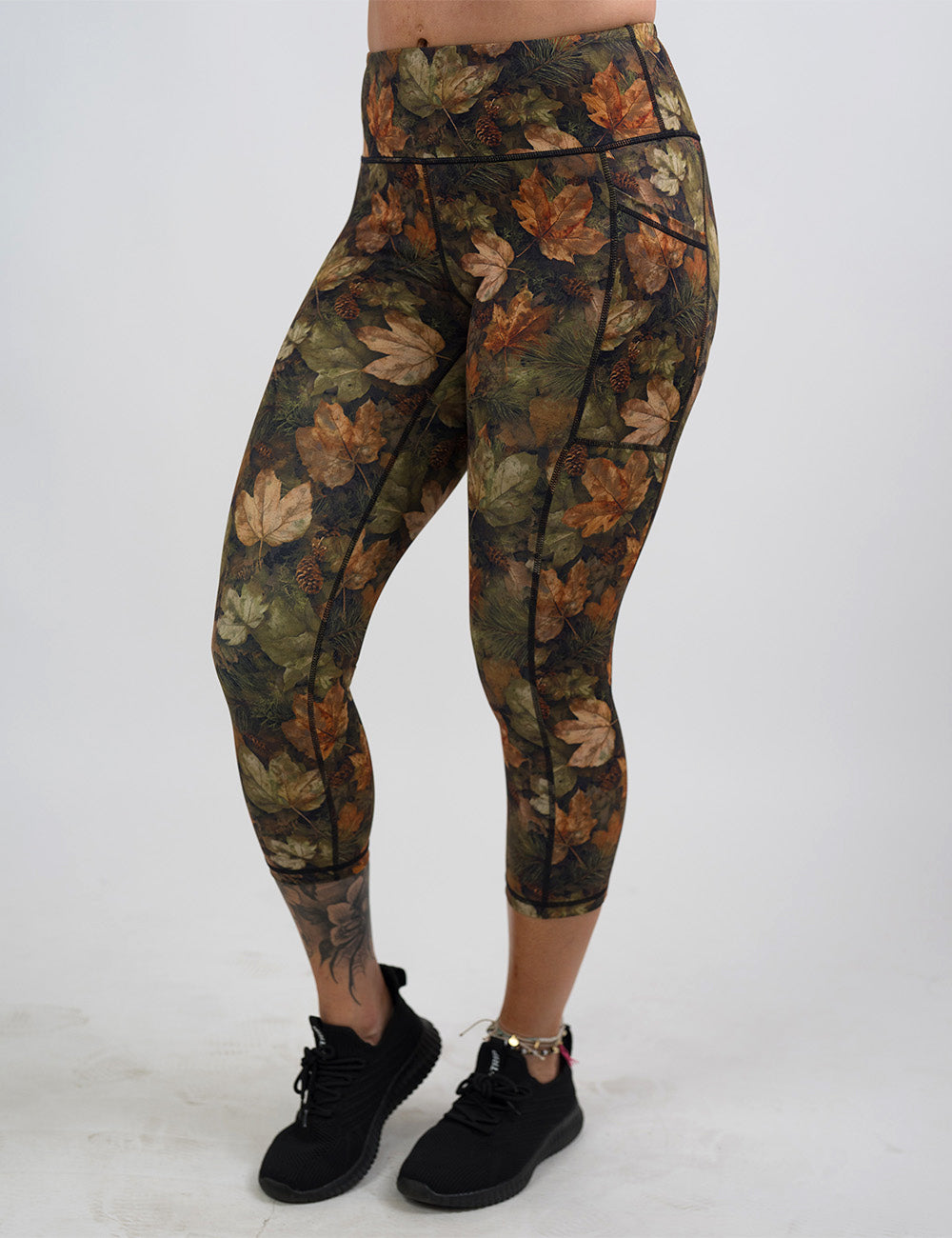 front of the forest floor covered in leaves capri leggings against a white background