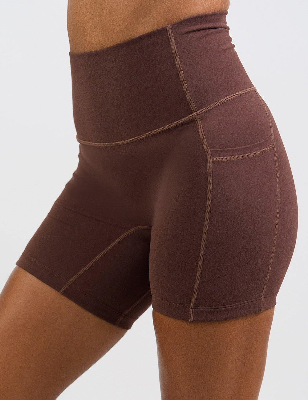 front of the 5 inch solid light brown shorts against a white background