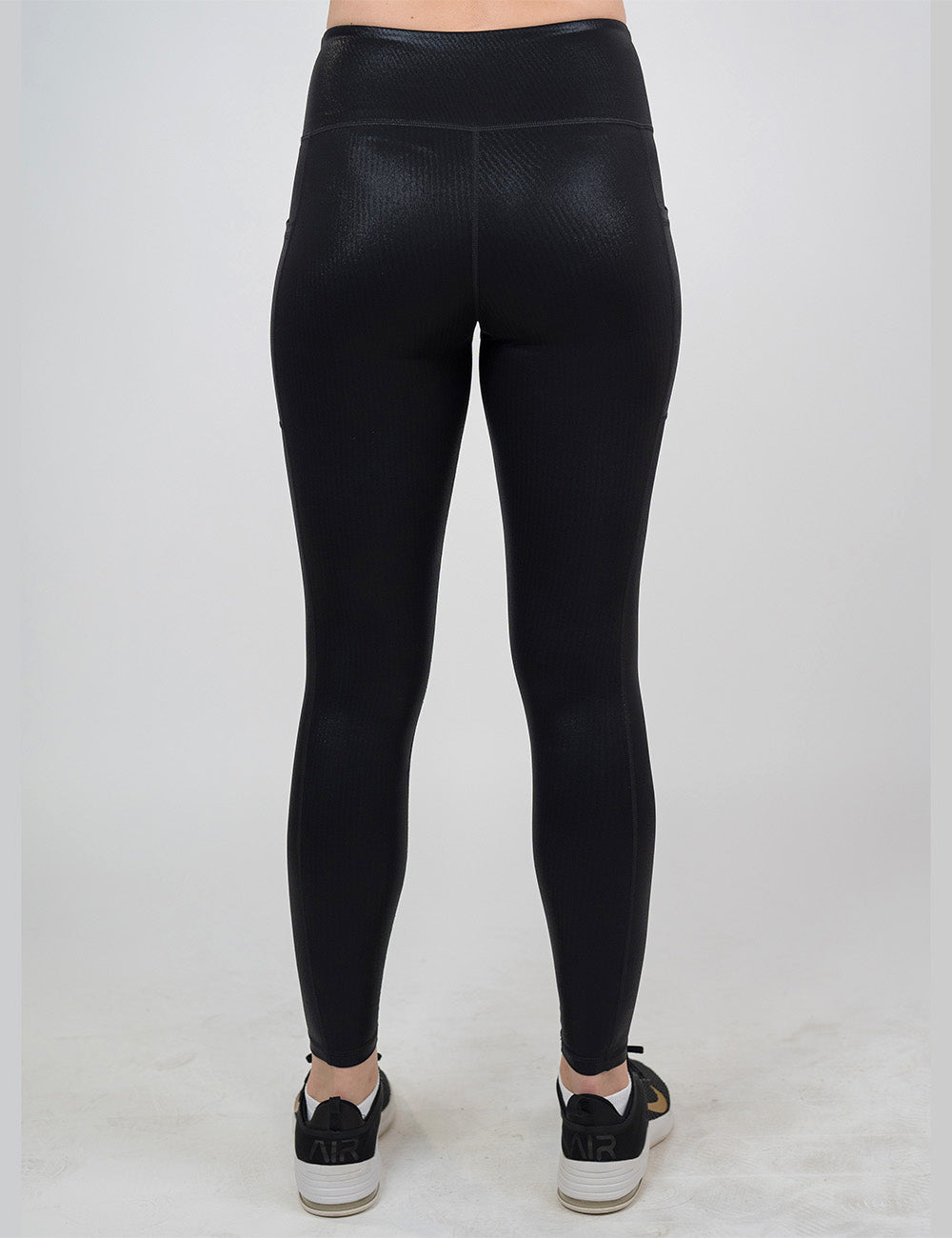back of the full length black leather leggings against a white background