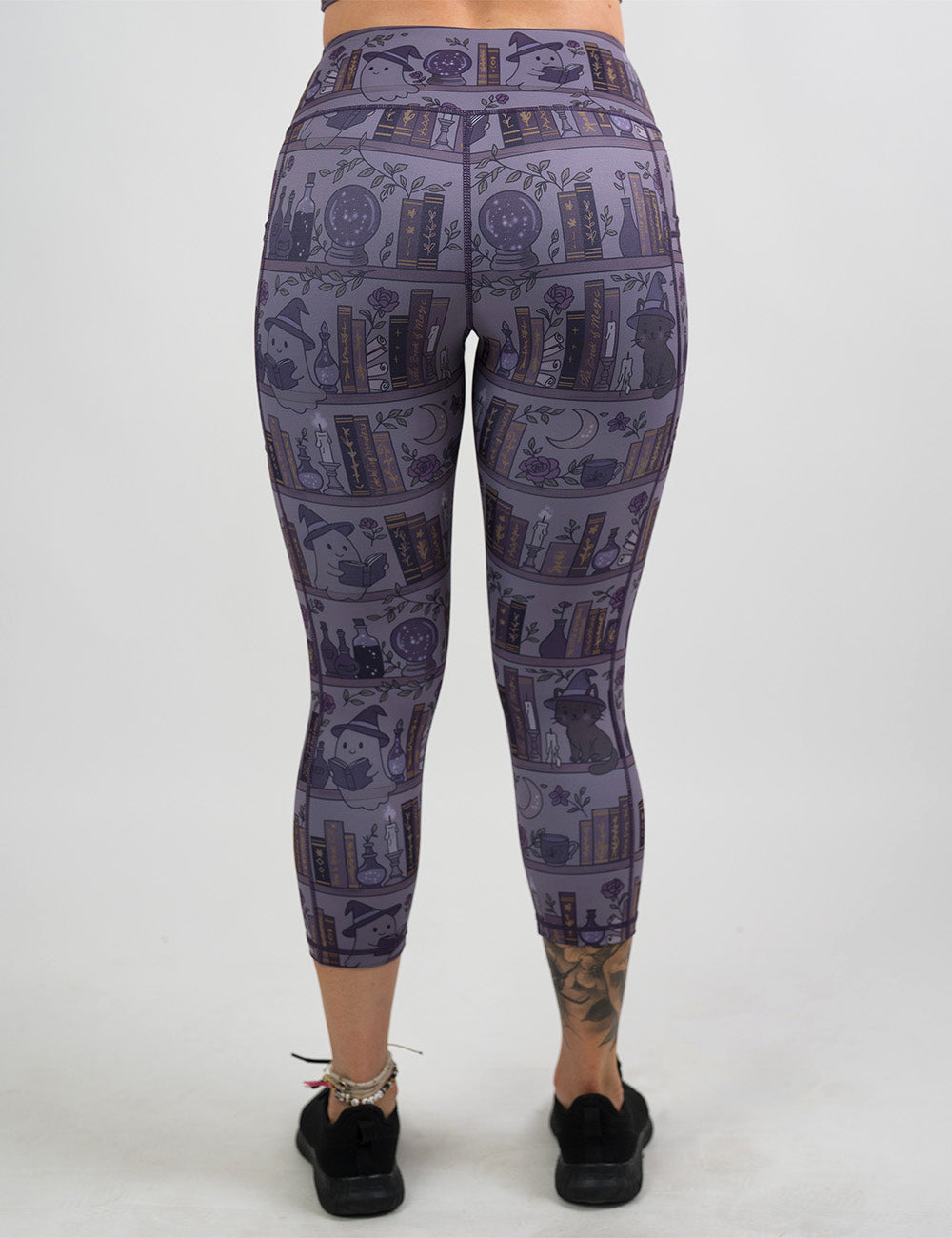 back of the capri ghosts and cats book shelves leggings against a white background