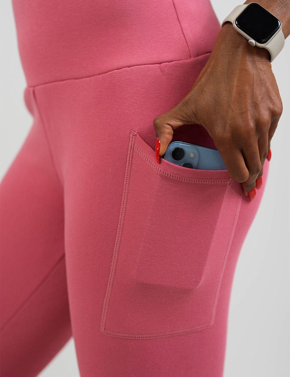 close up of the solid pink fleece lined leggings with a phone in its pocket