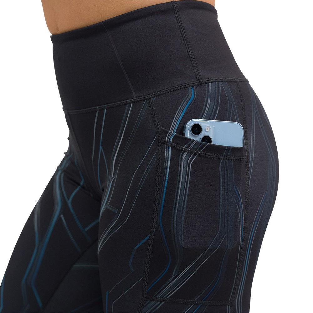 close up of black leggings with blue patterns on a white background with a phone in the pocket
