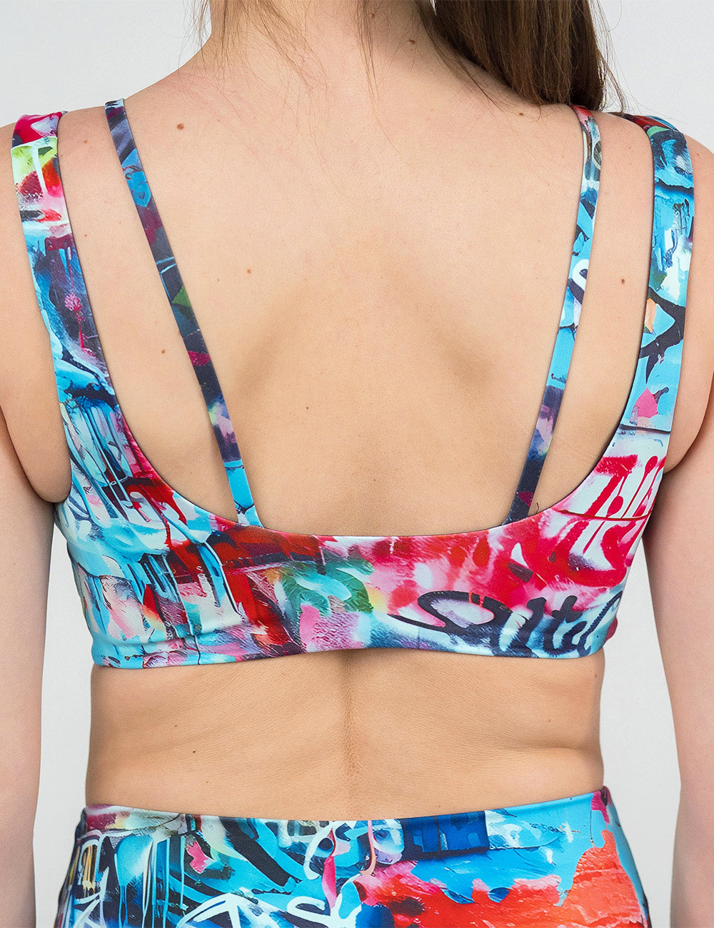 back of of the multi color graffiti vista bra against a white background