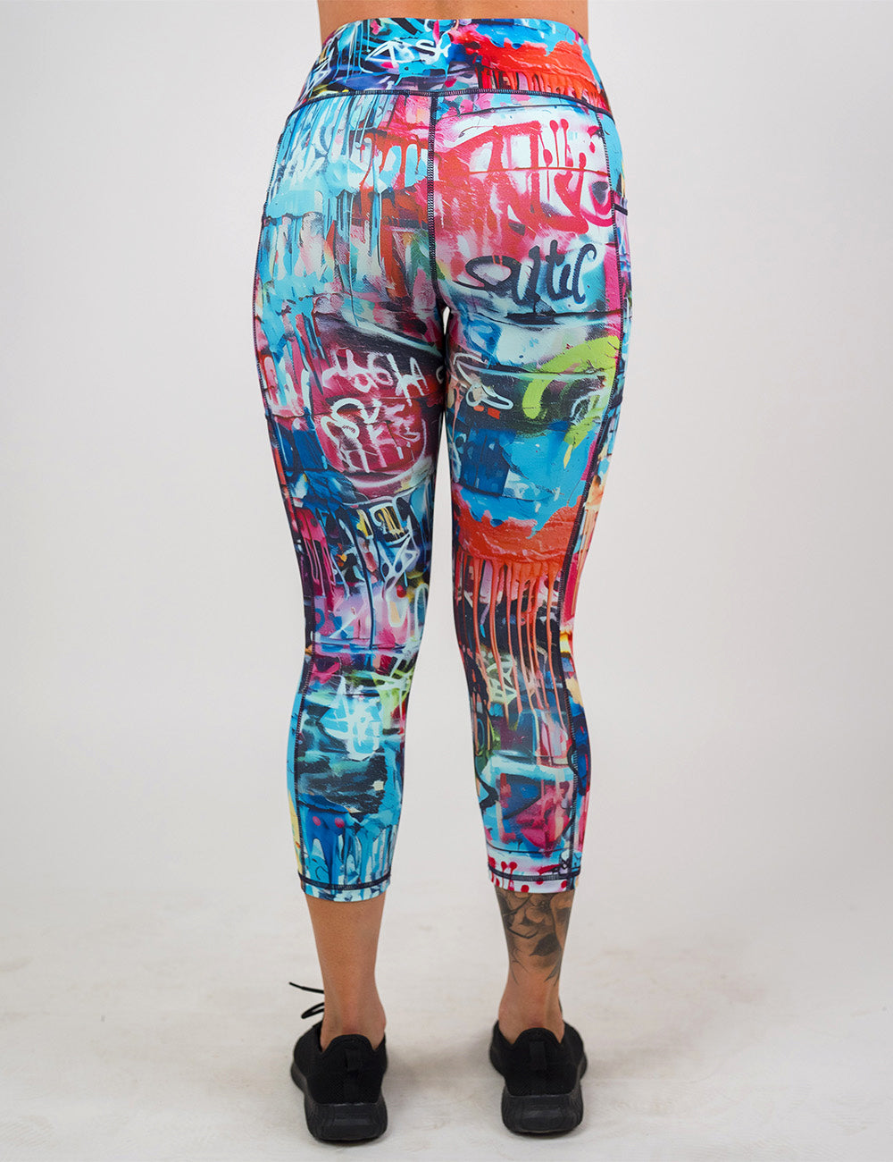 back of the multi colored graffiti covered capri leggings against a white background