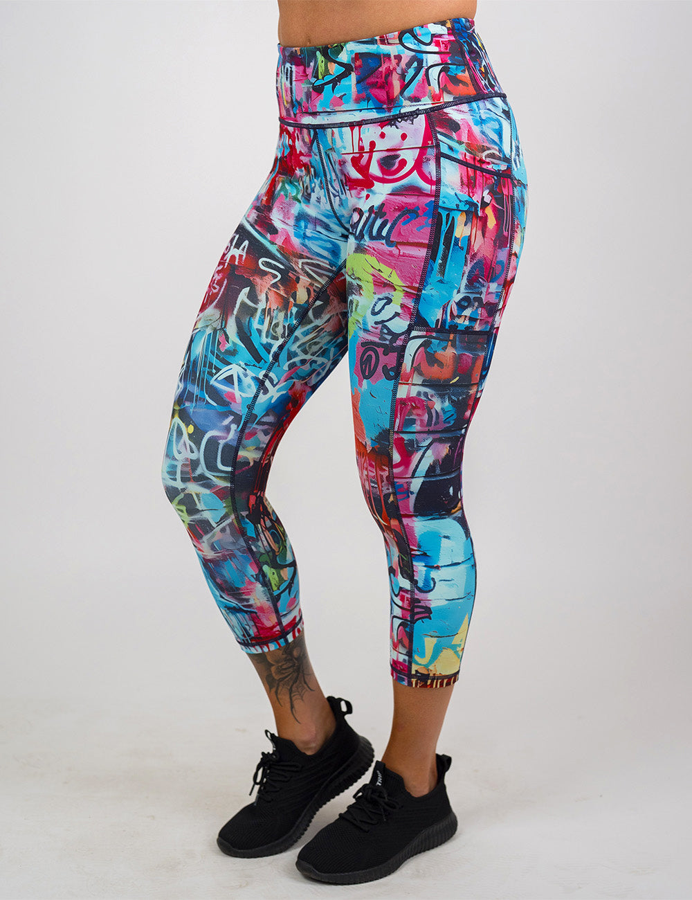 front of the multi colored graffiti covered capri leggings against a white background