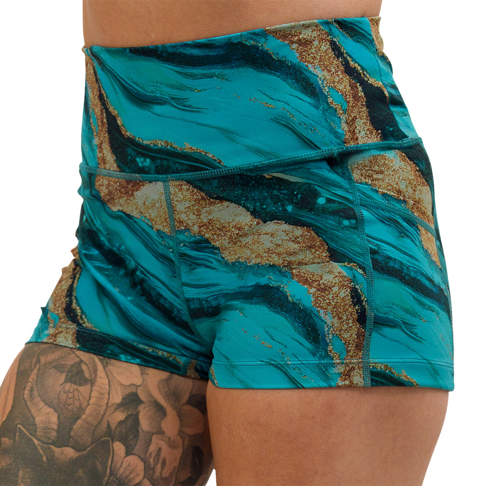 close up of the 2.5 inch blue ocean with gold streaks patterned shorts against a white background