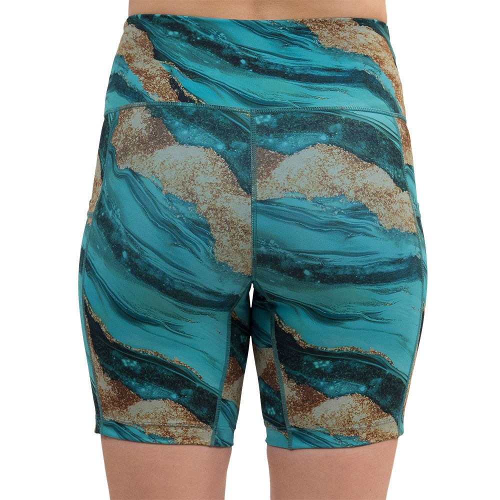 back of the 7 inch blue ocean with gold streaks patterned shorts against a white background