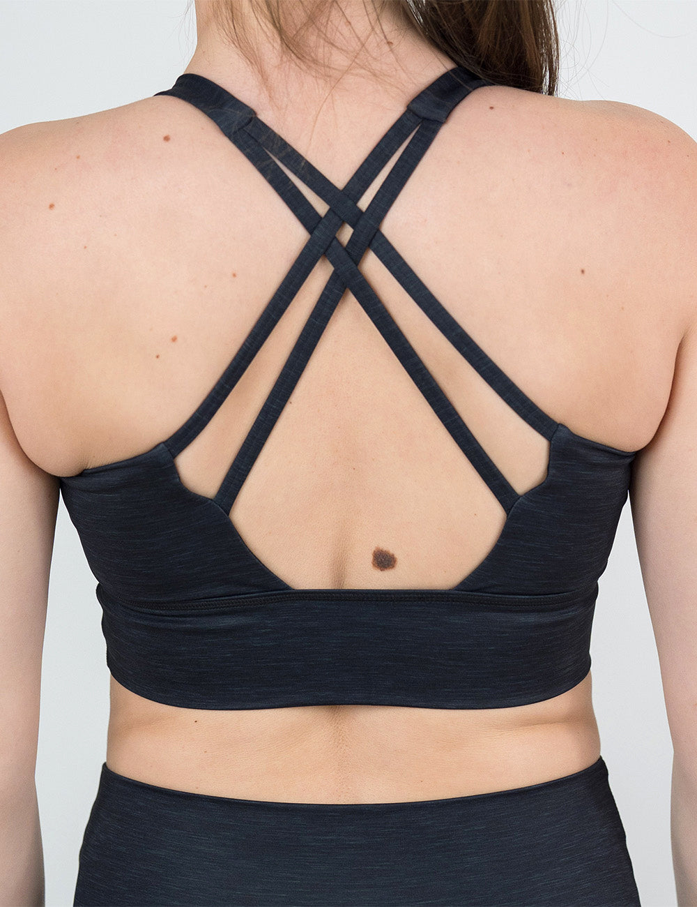 back of the black heather pattern longline bra against a white background