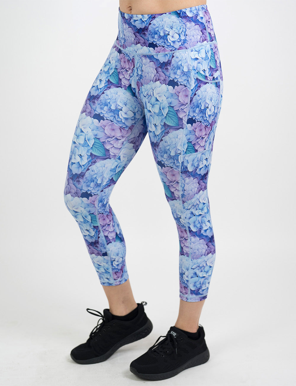 front of the capri pastel blue and purple hydrangea flower pattern leggings against a white background