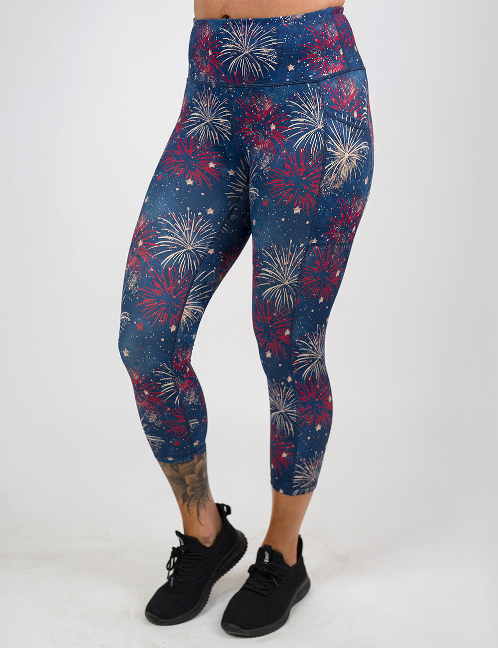 front of the capri blue leggings with a red and white fireworks pattern against a white background