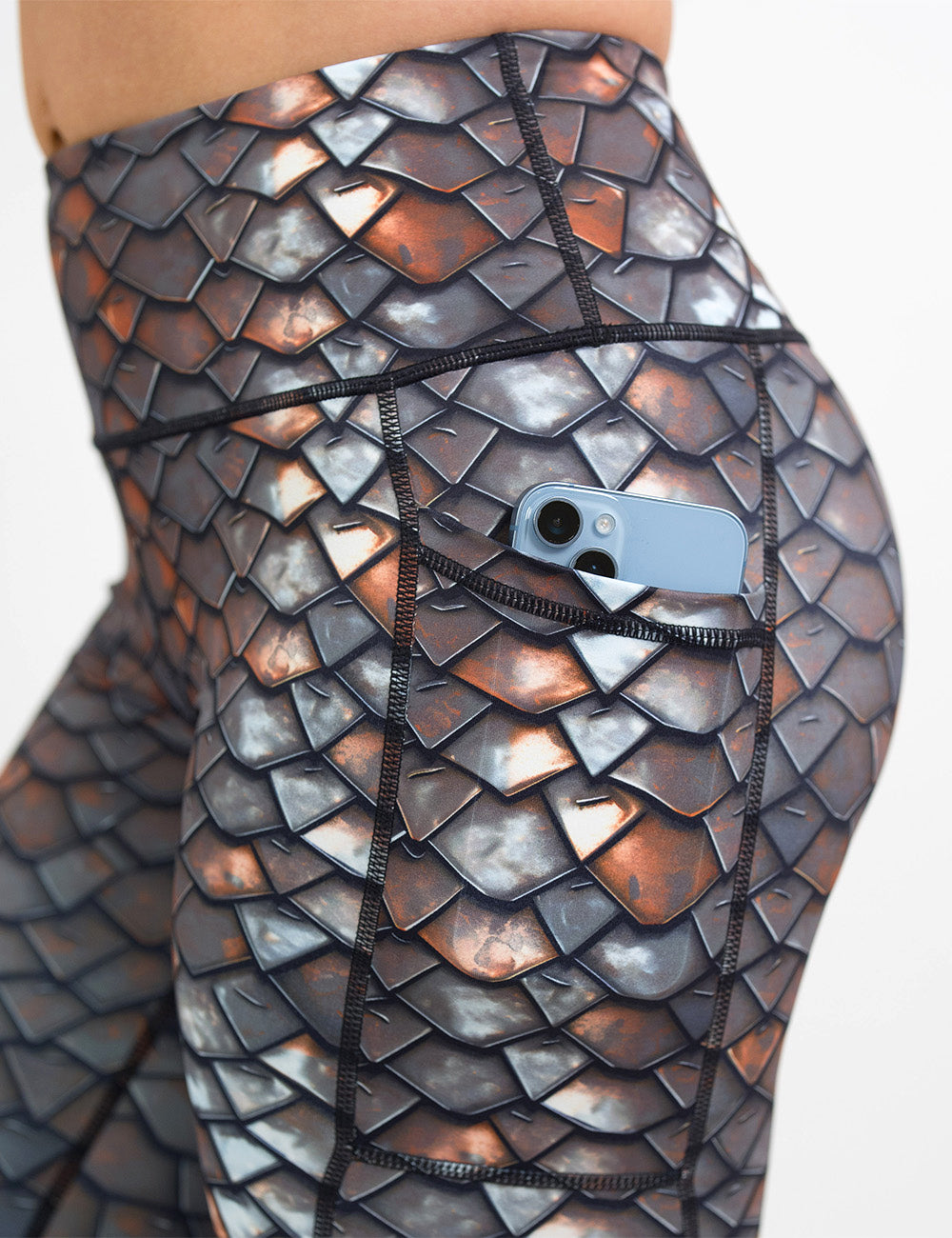 close up of the iron scales pattern leggings with a phone in its pocket