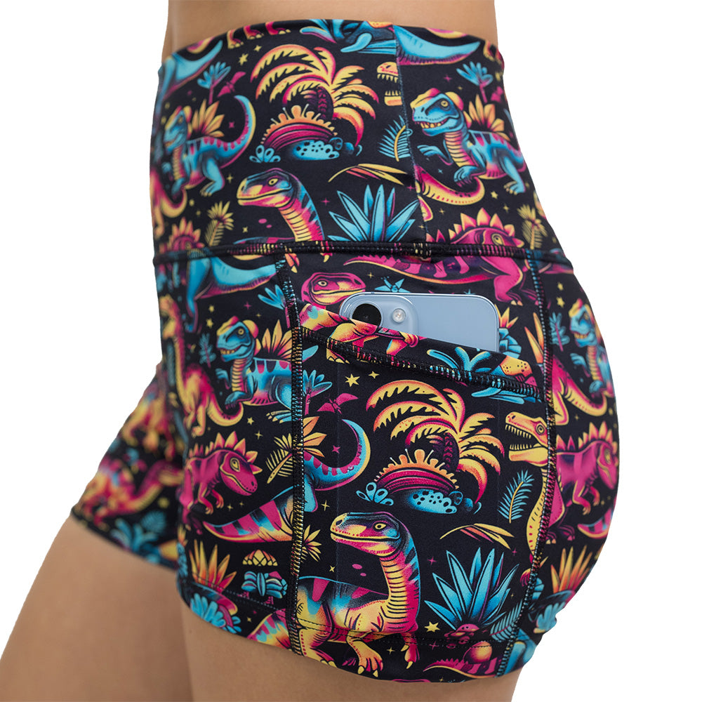 close up of a phone in the pocket of the dinosaur print 2.5 inch shorts