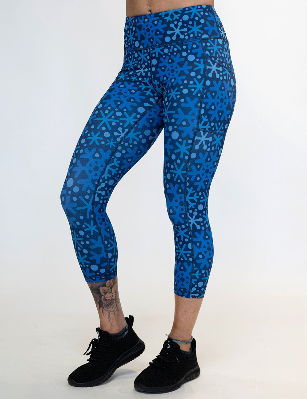 front of the blue snowflakes on a dark blue background capri leggings against a white background