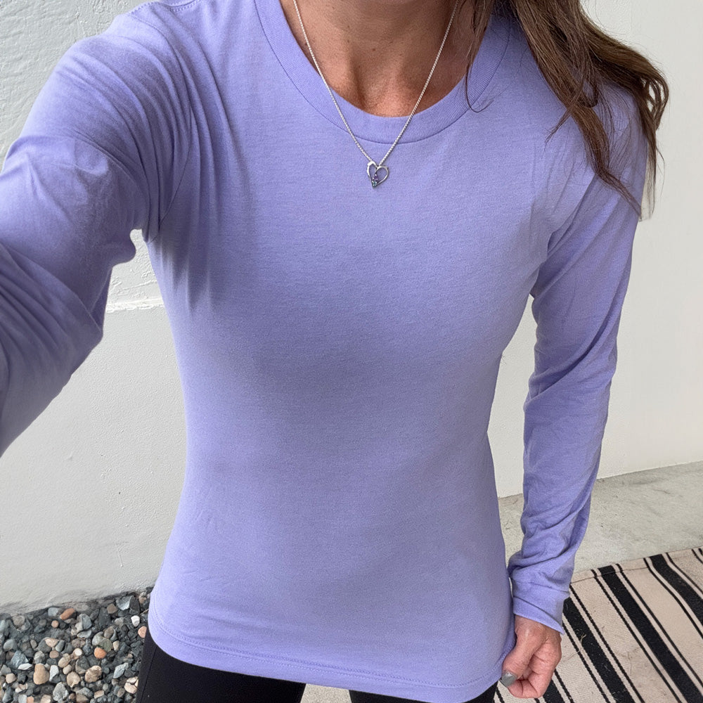 Person wearing a purple long-sleeve shirt against a neutral background