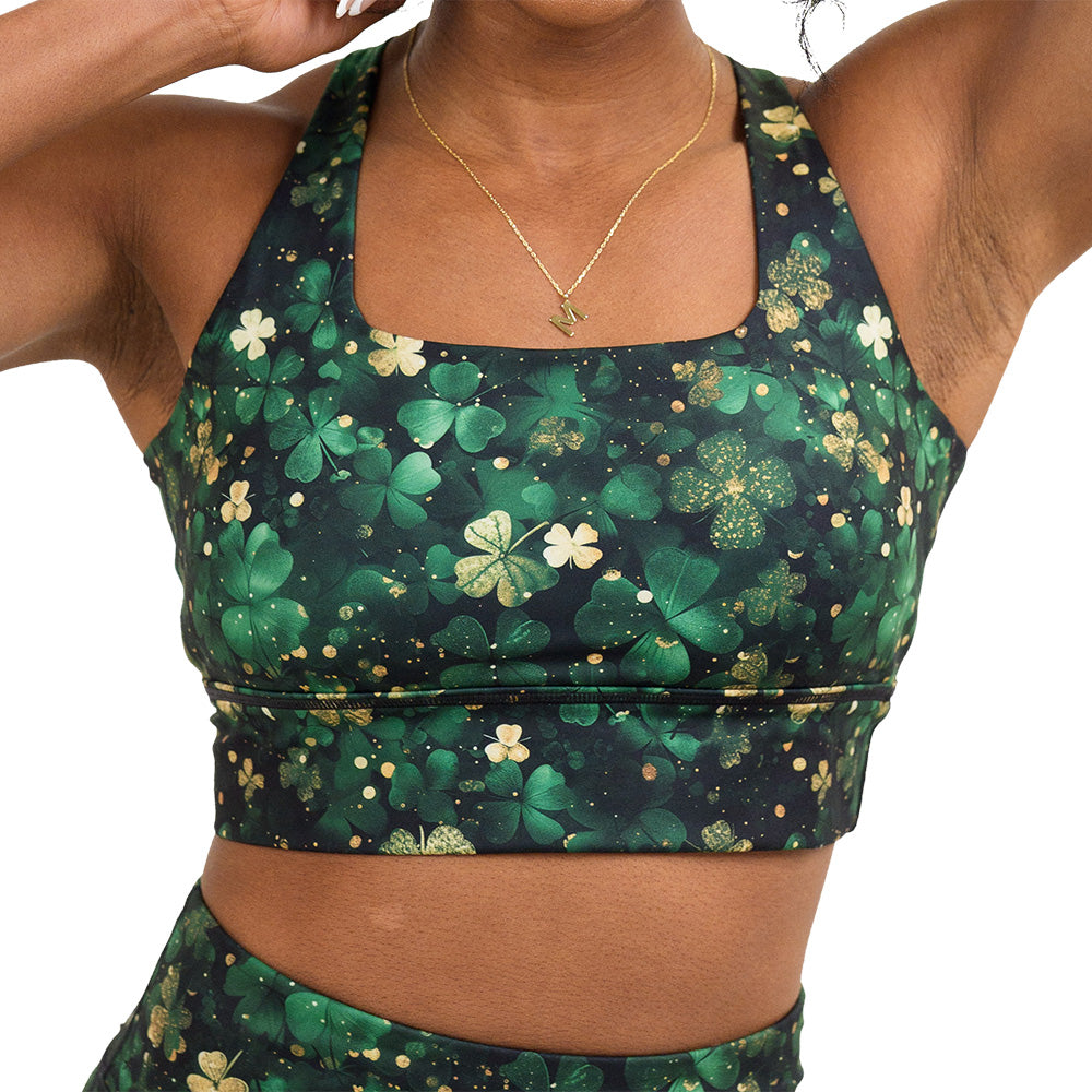 front of the green and gold shamrock patterned longline bra against a white background