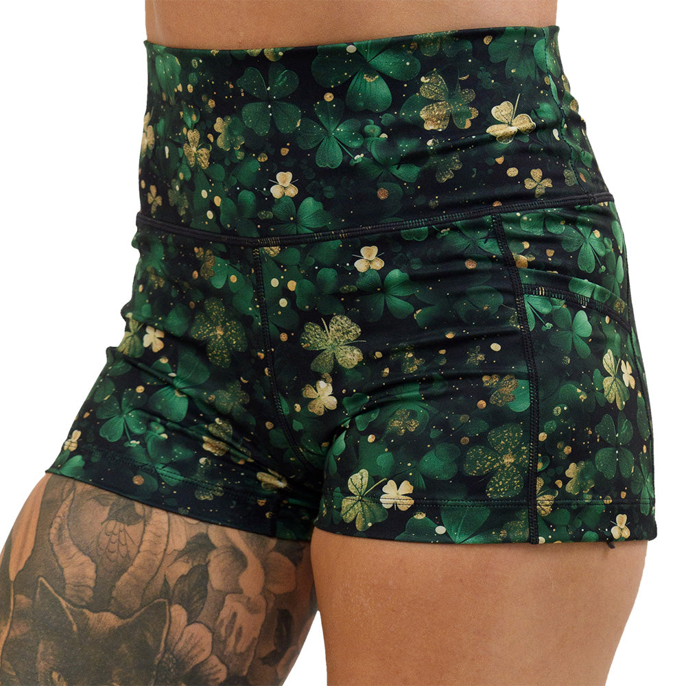 close up of the green and gold shamrock patterned 2.5 inch shorts against a white background
