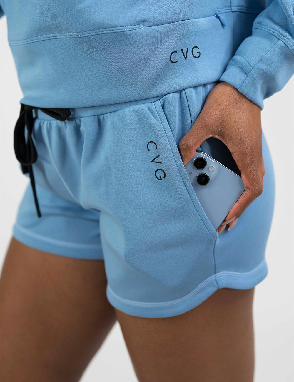 close up of the blue shorts with black drawstring showing the pocket holding a phone