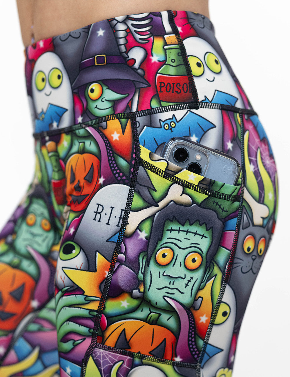 close up of the Halloween characters leggings with a phone in its pocket