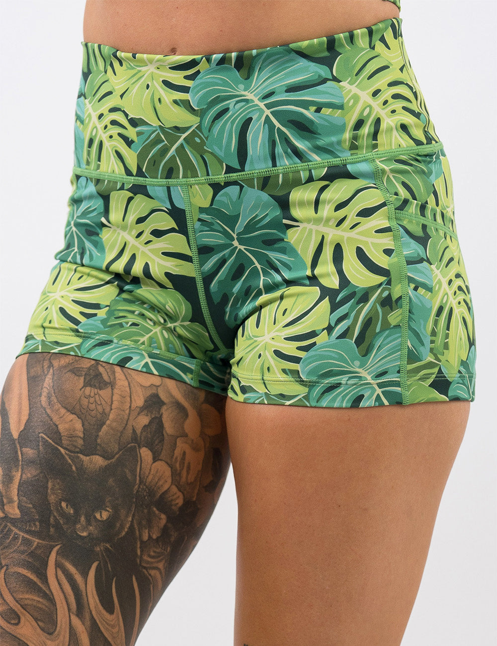 front of the 2.5 inch green tropical leaves shorts against a white background