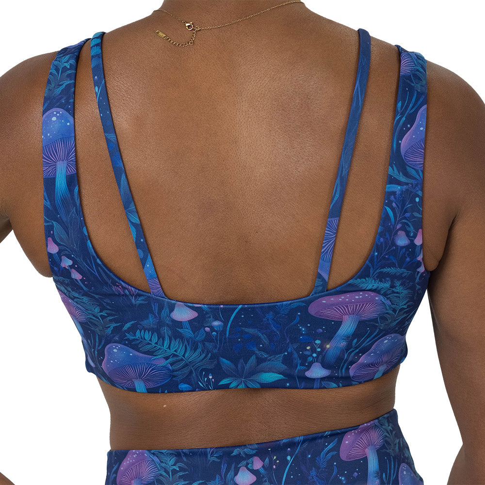 back of the sports bra with a blue and purple mushroom and foliage design on a white background