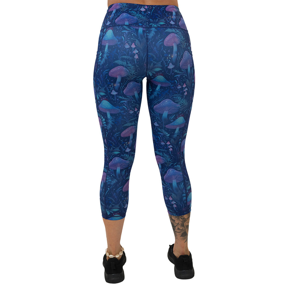 back of the leggings with a blue and purple mushroom and foliage design on a white background