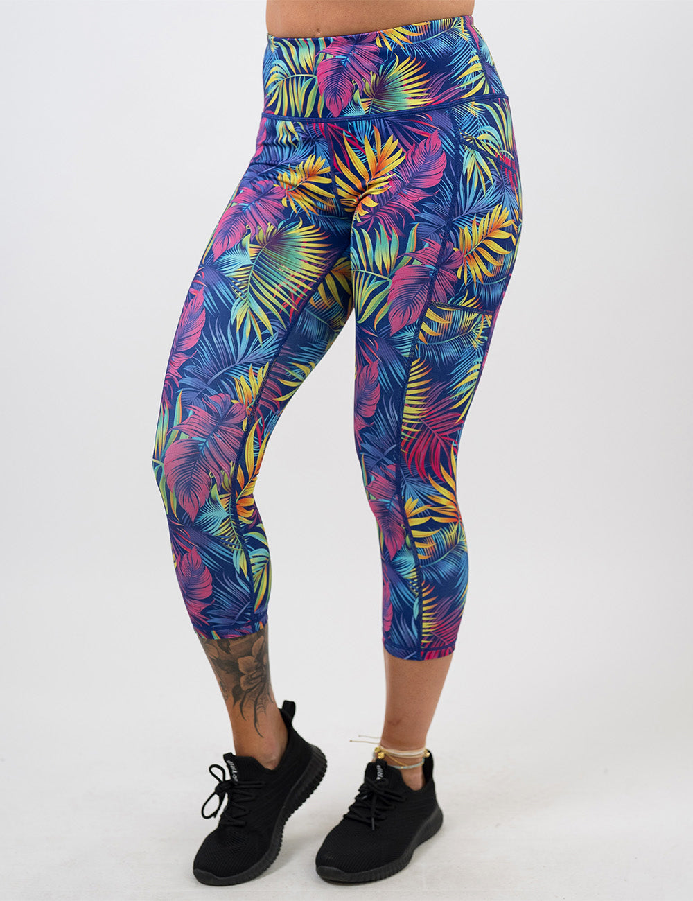 front of the capri vibrant rainforest leaves leggings against a white background