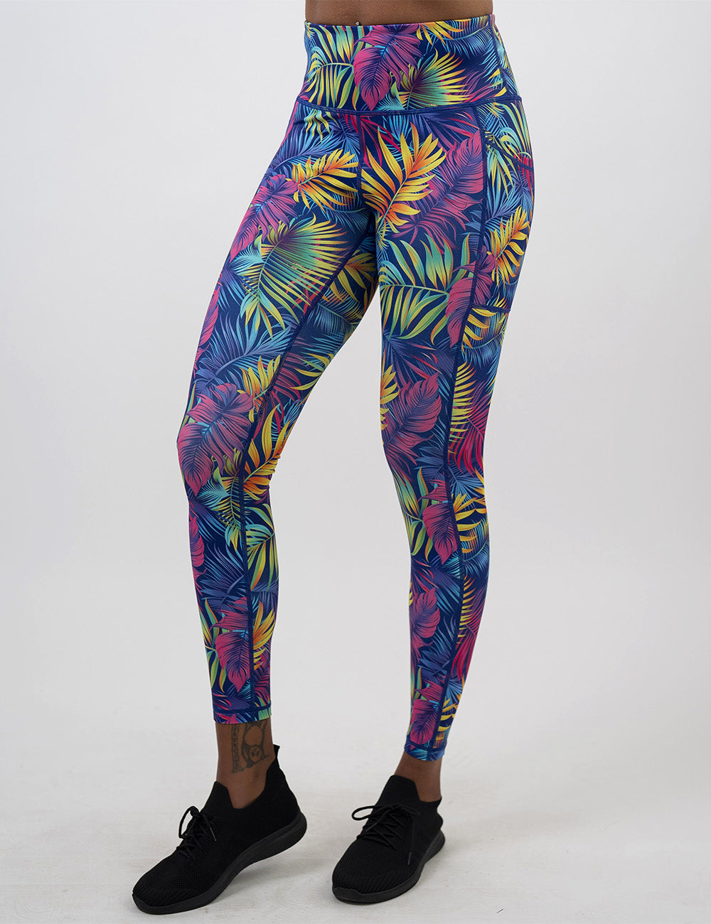 front of the full length vibrant rainforest leaves leggings against a white background