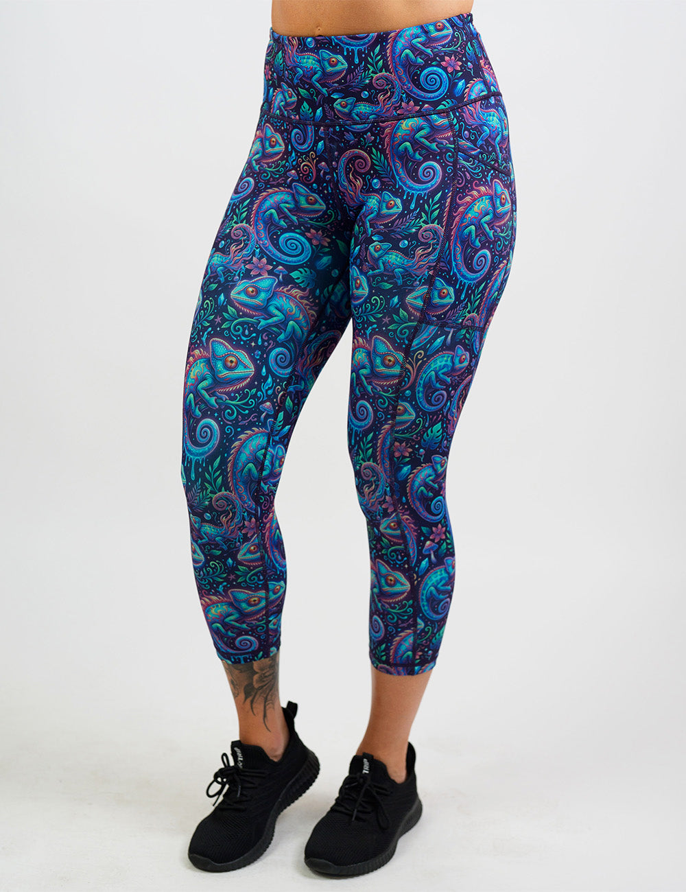 front of the orange, blue, and red chameleons surrounded by plants capri leggings against a white background