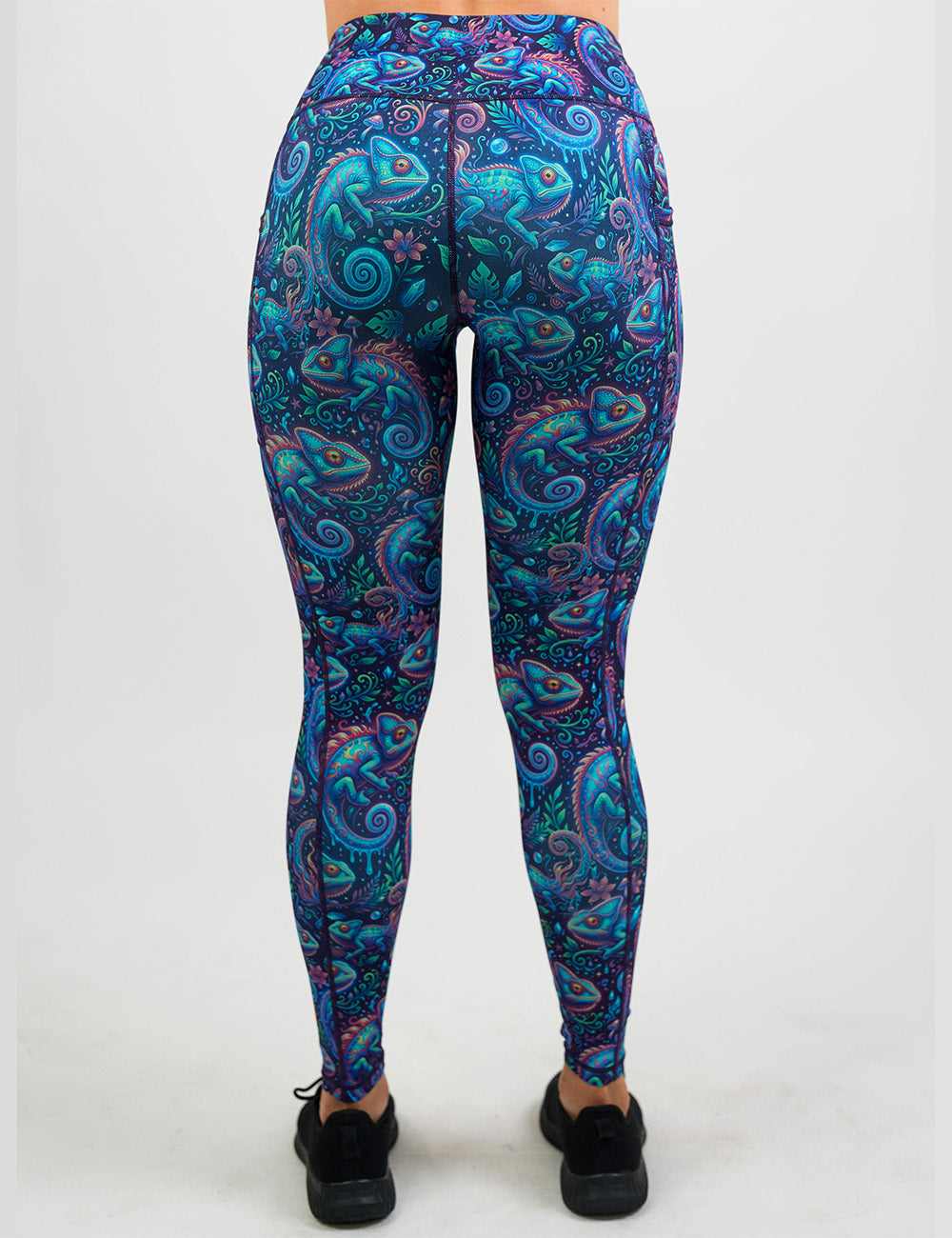 back of the orange, blue, and red chameleons surrounded by plants full length leggings against a white background