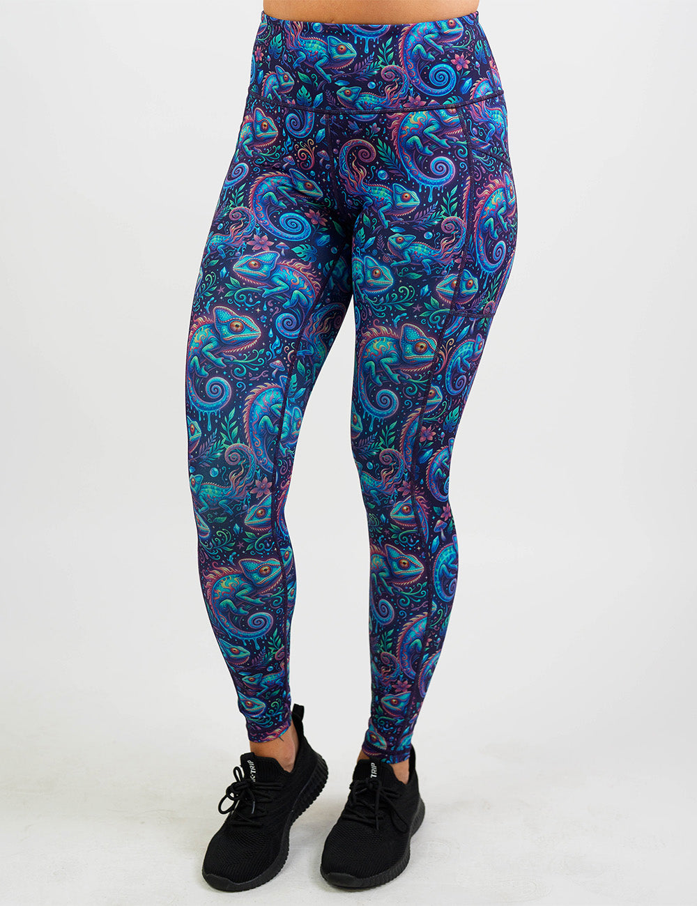 front of the orange, blue, and red chameleons surrounded by plants full length leggings against a white background