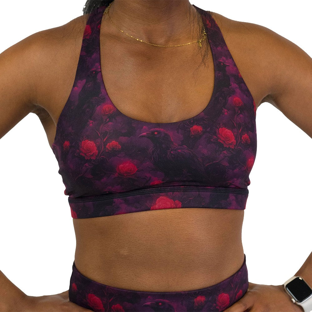 Black sports bra with red floral and crow pattern on it 