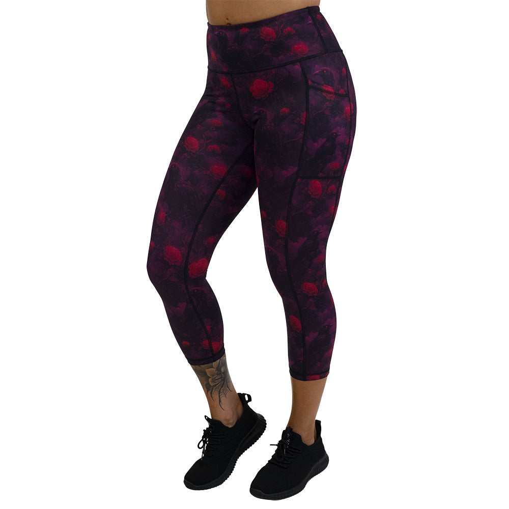 Black leggings with red floral and crow pattern on it