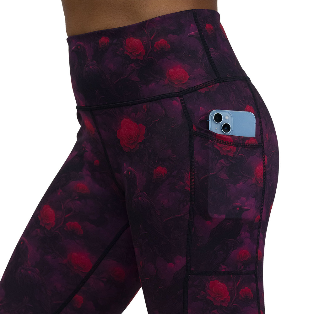 Black leggings with red floral and crow pattern on it