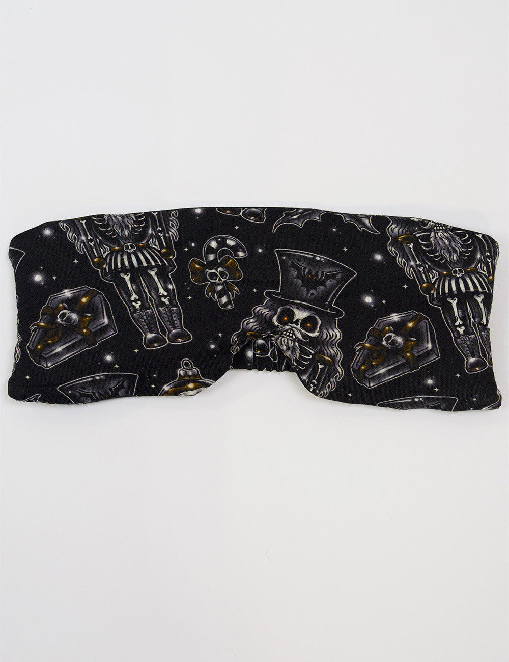 front of the black nutcrackers, mistle toe, and Christmas ornaments eye mask against a white background