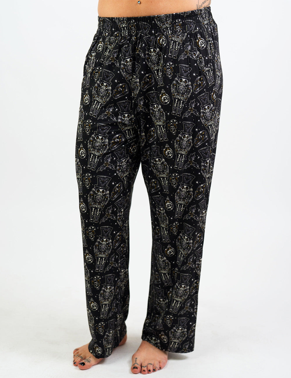 front of the black nutcrackers, mistle toe, and Christmas ornaments pajama bottoms against a white background