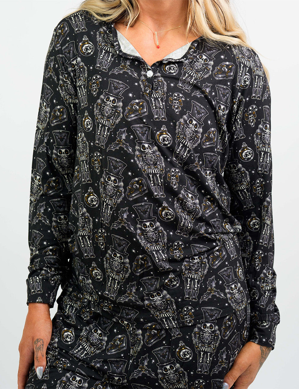 front of the black nutcrackers, mistle toe, and Christmas ornaments pajama top against a white background