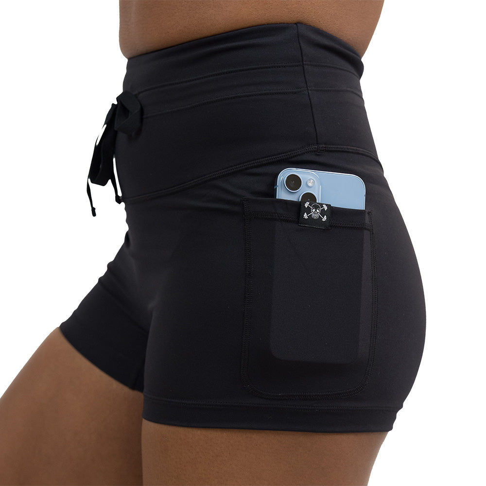 close up of the omni black 2.5 inch shorts with a phone in the pocket