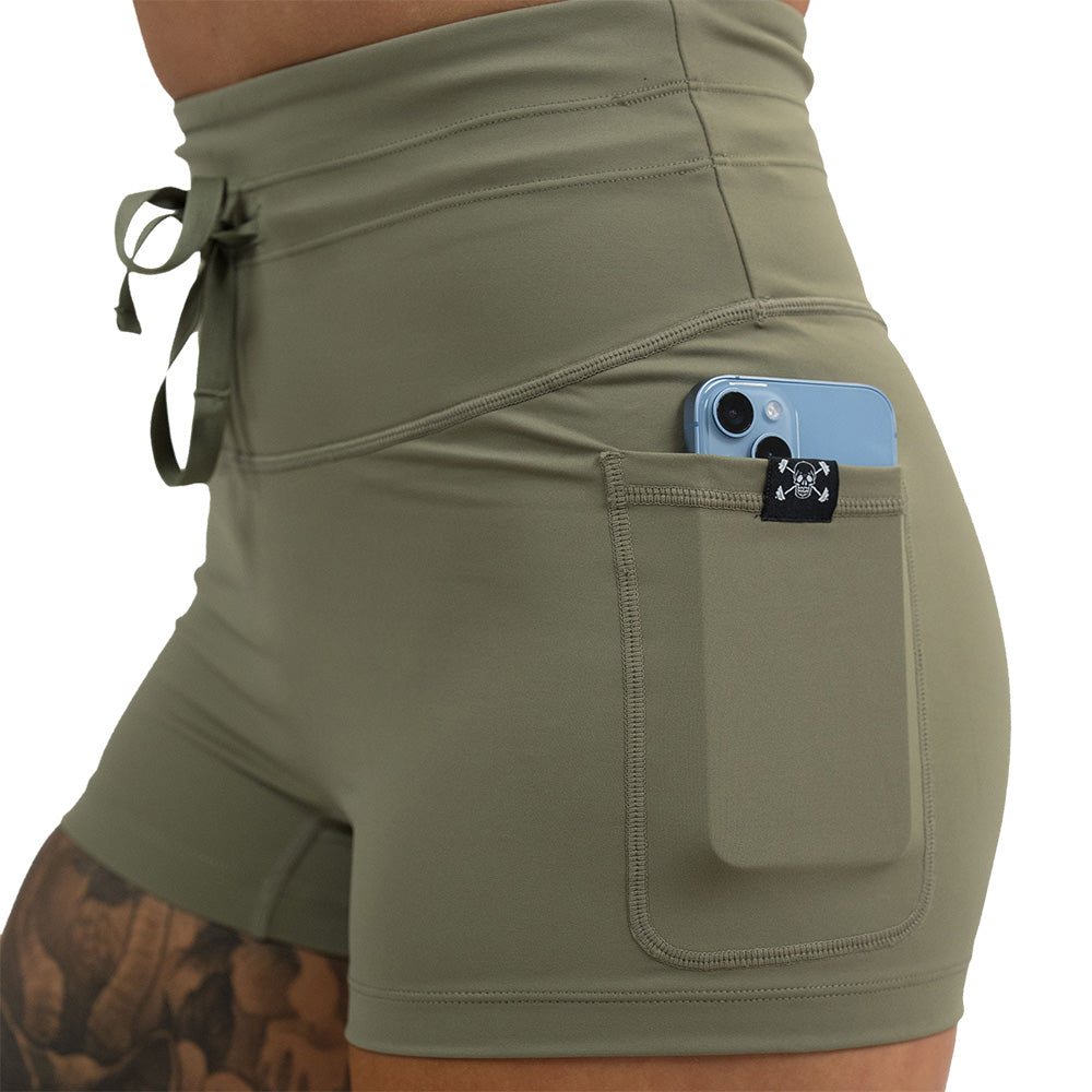 omni green tea 2.5 inch shorts with a phone in the pocket against a white background