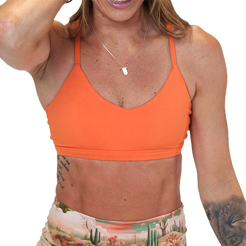 model wearing a solid orange sports bra