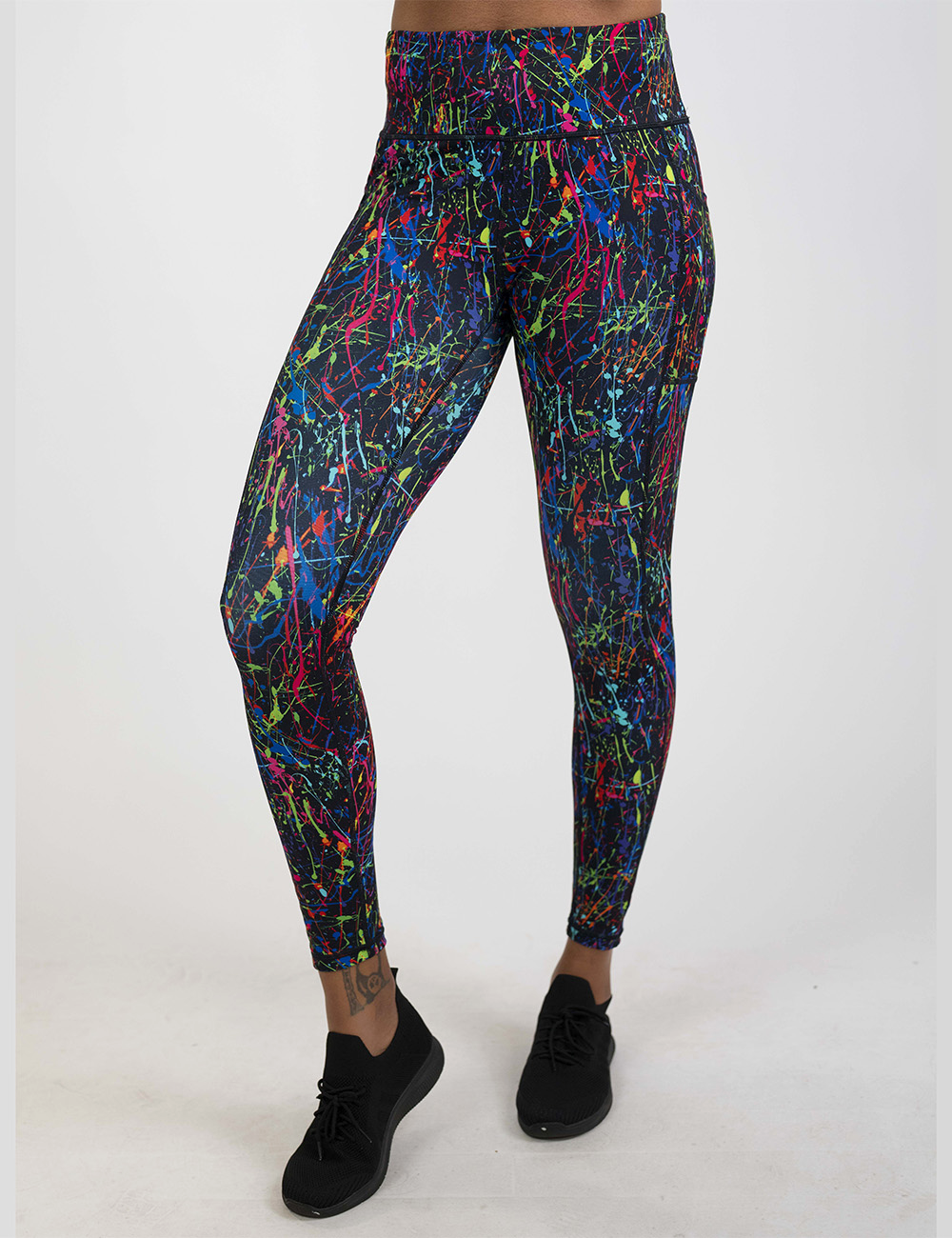 rainbow paint splatter against a black background pattern full length leggings against a white background