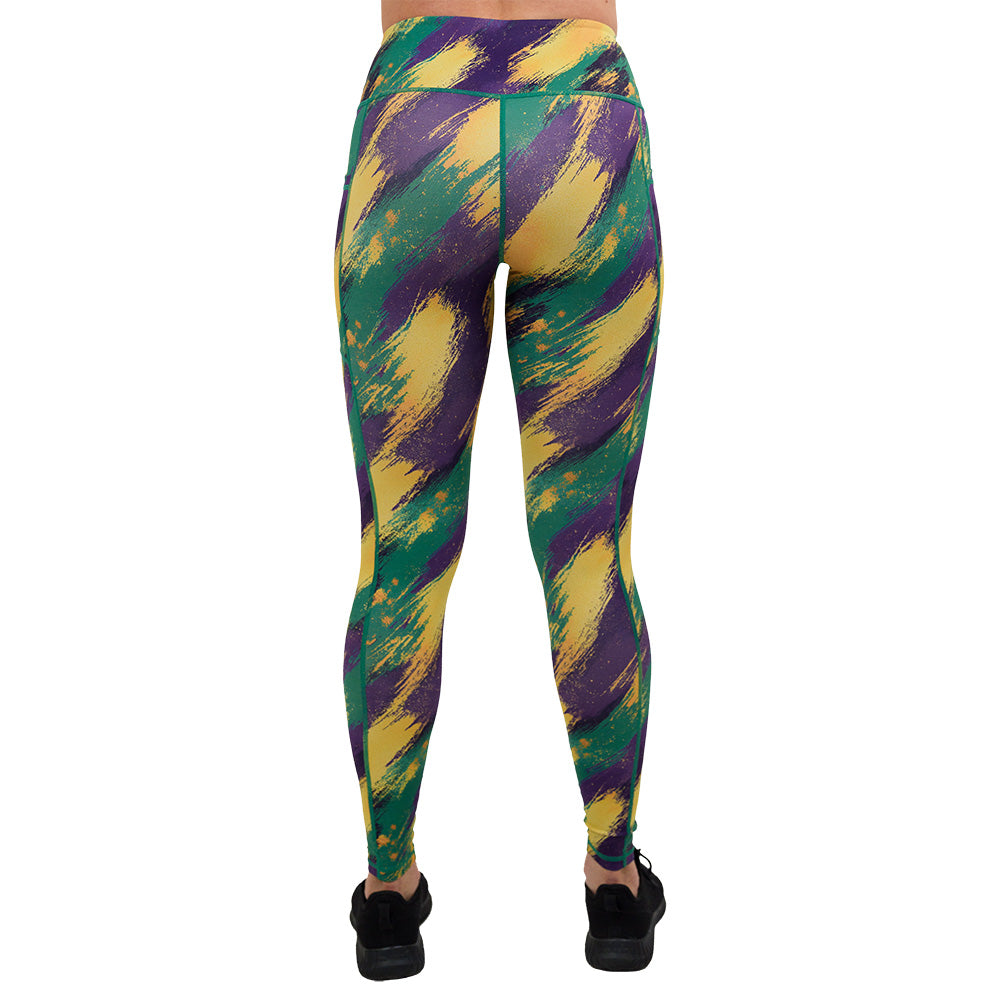 back of the full length green, yellow. and purple patterned leggings against a white background