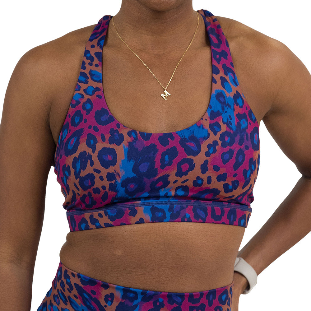 front of the cheetah print against a yellow, blue, and purple background pattern bra against a white background